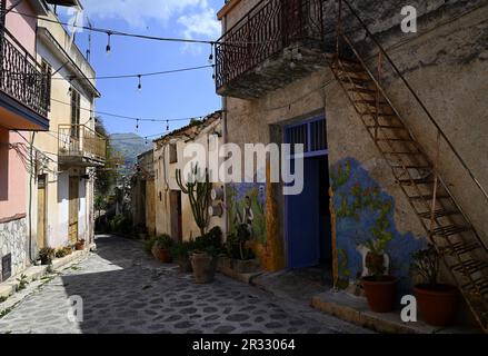 Maisons rurales traditionnelles avec peintures murales peintes à la main sur les ruelles pavées de Parrini en Sicile Italie. Banque D'Images