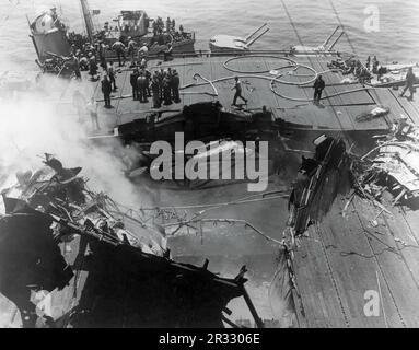 Vue des dégâts sur le pont de l'USS Bunker Hill à la suite d'une attaque de deux pilotes japonais kamikaze, juin 1945. Lorsque le Japon était confronté à la défaite de fin 1944, il a choisi de détruire des navires américains par des attentats-suicides, connus sous le nom de Kamikaze.ces attaques étaient une arme physique et psychologique puissante et ont coulé un total de 47 navires pour un coût de plus de 3000 pilotes et avions. À la fin de 1944, la marine américaine était suffisamment importante pour que les pertes soient insignifiantes et qu’elles n’aient pas modifié le cours de la guerre. Banque D'Images