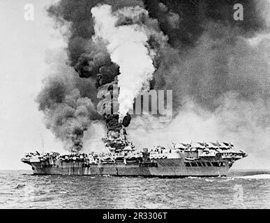 Le porte-avions HMS formidable (R67) en feu après avoir été frappé par un kamikaze au large de Sakishima Gunto. Formidable a été frappé à 1130 heures, le kamikaze faisant une bosselure massive d'environ 3 m de long, 0,6 m de large et de profondeur dans le pont de vol blindé. Une grande trappe en acier s'est envolée à travers le pont du hangar et la chaufferie centrale, où elle a rompu une ligne de vapeur, et est venue se reposer dans un réservoir de carburant, ce qui a déclenché un incendie majeur dans le parc de l'avion. Huit membres d'équipage ont été tués et quarante-sept ont été blessés. Un Corsair de Vought et dix Avengers de Grumman ont été détruits Banque D'Images