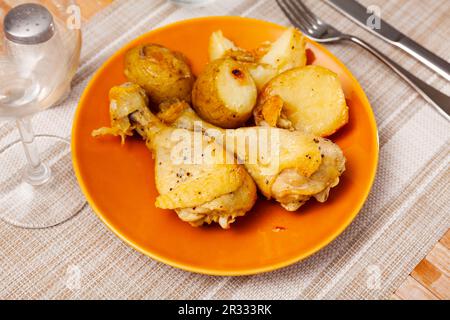 Cuisse de poulet au barbecue avec pommes de terre bouillies sur l'assiette Banque D'Images