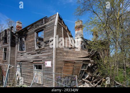 Bâtiment résidentiel en bois partiellement brûlé et effondré lors d'une journée ensoleillée de printemps dans le quartier de Kopli à Tallinn, Estonie Banque D'Images