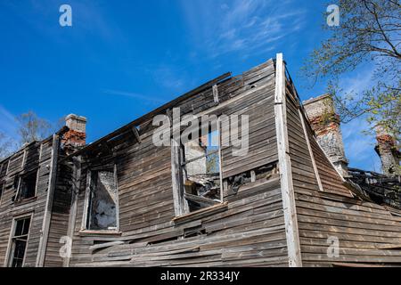 Maison en bois partiellement brûlée contre le ciel bleu dans le quartier de Kopli à Tallinn, Estonie Banque D'Images