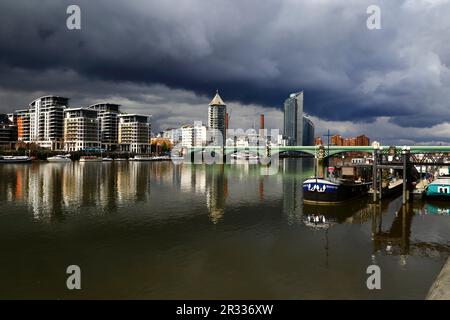 Battersea Railway Bridge / Chelsea River Bridge de l'autre côté de la Tamise et de la Belvedere Tower (Chelsea Harbour) sous un ciel sombre, Londres, Royaume-Uni Banque D'Images