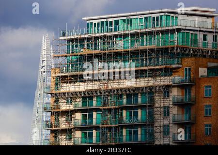 Personnes assises sur le balcon d'un nouvel immeuble d'appartements sur le Albert Embankment, la tour Shard en arrière-plan sous un ciel orageux, Londres, Royaume-Uni Banque D'Images