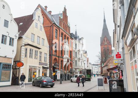 Flensburg, Allemagne - 10 février 2017: Vue sur la rue de la vieille ville de Flensburg avec l'église Sainte Marie sur un fond. Les gens ordinaires marchent dans la rue Banque D'Images