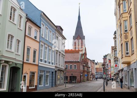 Flensburg, Allemagne - 9 février 2017: Vue sur la rue de la vieille ville de Flensburg avec l'église Sainte Marie sur un fond. Les gens ordinaires sont dans la rue Banque D'Images