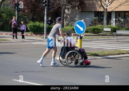 Belgrade, Serbie, 23 avril 2023 : un homme poussant un fauteuil roulant participe à une course marathon Banque D'Images