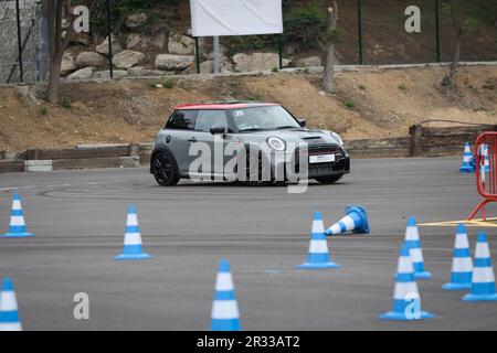 Expérience de conduite d'essai de Mini Cooper avec des membres de la conduite publique à vitesse autour d'un circuit avec bornes Banque D'Images