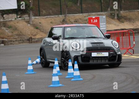 Expérience de conduite d'essai de Mini Cooper avec des membres de la conduite publique à vitesse autour d'un circuit avec bornes Banque D'Images