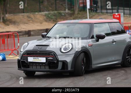 Expérience de conduite d'essai de Mini Cooper avec des membres de la conduite publique à vitesse autour d'un circuit avec bornes Banque D'Images