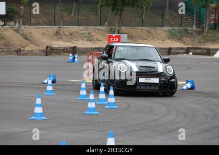 Expérience de conduite d'essai de Mini Cooper avec des membres de la conduite publique à vitesse autour d'un circuit avec bornes Banque D'Images