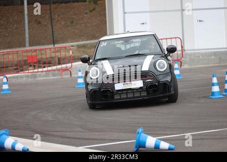 Expérience de conduite d'essai de Mini Cooper avec des membres de la conduite publique à vitesse autour d'un circuit avec bornes Banque D'Images