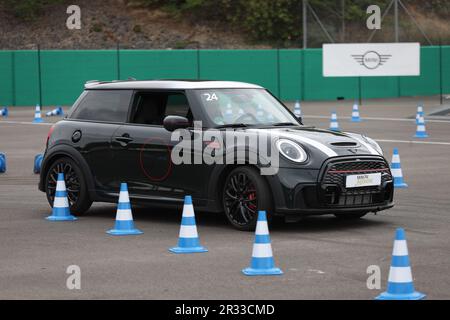 Expérience de conduite d'essai de Mini Cooper avec des membres de la conduite publique à vitesse autour d'un circuit avec bornes Banque D'Images