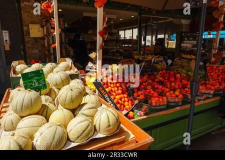 Melons frais et autres fruits joliment exposés à l'extérieur d'un marché de la rue Cler dans le 7th arrondissement de Paris, France. Banque D'Images