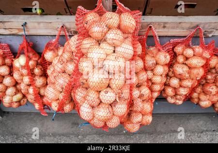 Oignons frais biologiques emballés dans des sacs à vendre sur le marché Banque D'Images