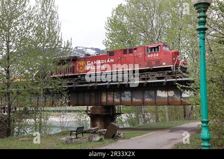 La locomotive du CP Railway traverse un pont fluvial. Montagnes en arrière-plan Banque D'Images