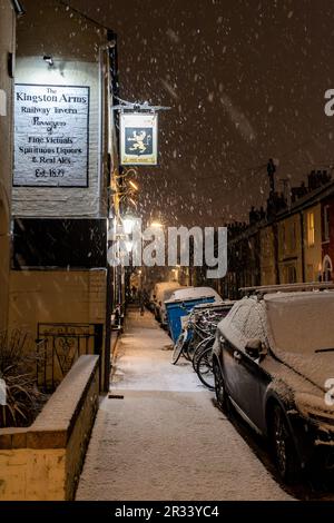 Le panneau pour le pub Kingston Arms brille lors d'une nuit d'hiver enneigée sur Kingston Street, à la sortie de Mill Road, Cambridge, Royaume-Uni Banque D'Images