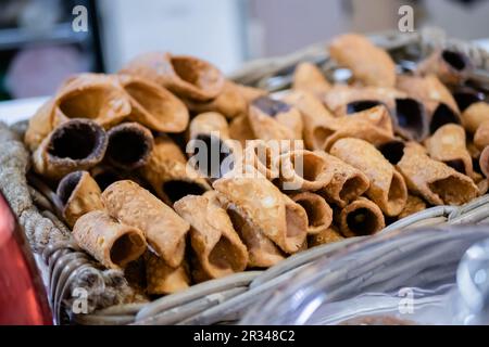 Cannoli frits et sautés dans un panier sur le comptoir du marché alimentaire Banque D'Images