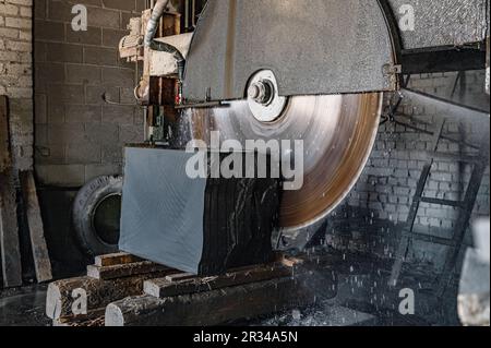 Scie pour la coupe de granit. Le grand couteau coupe le granit. Machine de traitement des pierres. Découpe de pierres en usine Banque D'Images