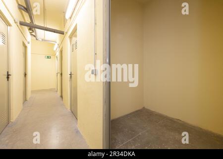 Une salle de stockage vide au rez-de-chaussée d'un immeuble résidentiel avec des murs peints en jaune crème Banque D'Images