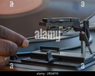 Détail d'une main femelle plaçant un disque en vinyle noir sur une platine vintage Banque D'Images