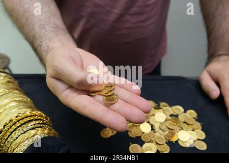 Mains d'homme tenant des pièces d'or. Montrant le quart d'or turc. Banque D'Images