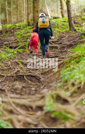 Mère et fils grimpant sur un sentier de randonnée dans une montagne Banque D'Images