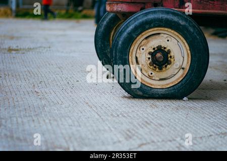 Vieux tracteur en caoutchouc sur un parc de ferme de près encore Banque D'Images