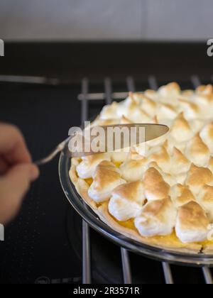 Délicieuse tarte au citron maison. Main humaine avec une pelle à dessert Banque D'Images