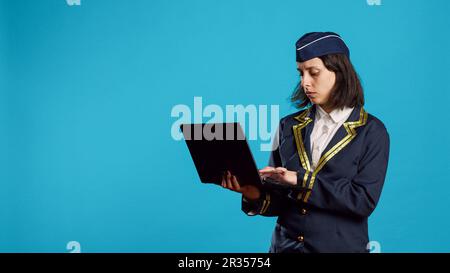Jeune femme avion de ligne utilisant un ordinateur portable en studio Banque D'Images