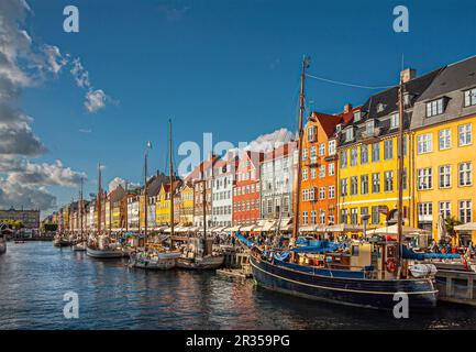 Copenhague, Danemark - 13 septembre 2010 : gamme de façades de restaurants emblématiques de Nyhavn aux couleurs vives sous un paysage bleu. Kongens Nyhavn à la fin, bateau Banque D'Images