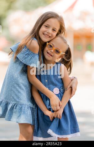 deux petites filles sont heureux de marcher dans le parc d'attractions en été. Journée internationale des enfants. Un enfant avec le syndrome de Down. Photo de haute qualité Banque D'Images