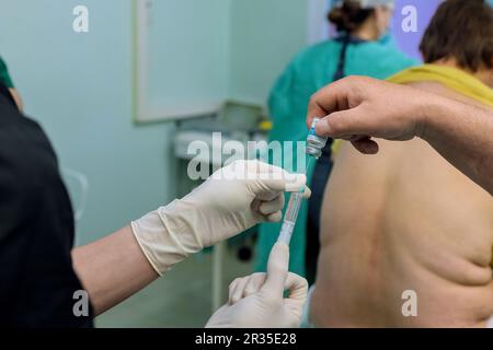 Au cours des préparations chirurgicales, le médecin administre des injections épidurales d'anesthésie rachidienne pour fournir un engourdissement de soulagement de douleur dans le corps inférieur Banque D'Images