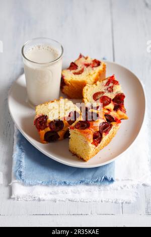 Gâteau de levure avec prunes servi avec un verre de lait de soja Banque D'Images