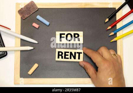Gros plan du modèle de petite maison sur des blocs en bois avec texte de garantie de loyer sur le tableau. vue de dessus. espace de copie vide. Banque D'Images