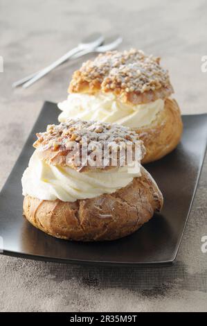 Profiteroles à la crème fouettée et cassante aux noix Banque D'Images