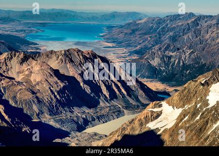 Survolant les alpes du Sud et ses sommets et lacs alpins. Le lac Pukaki est haut de l'écran et le lac Mueller est en premier plan avec le village de Mt Cook Banque D'Images