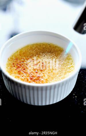 Crème brûlée caramélisée étant avec brûleur Bunsen Banque D'Images