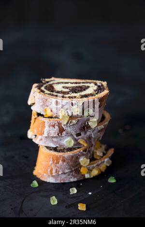 Une pile de tranches de gâteau aux graines de pavot roll avec du glaçage, des fruits séchés et des noix (Pologne) Banque D'Images