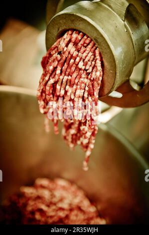Viande fraîchement hachée dans un moulin à viande (gros plan) Banque D'Images