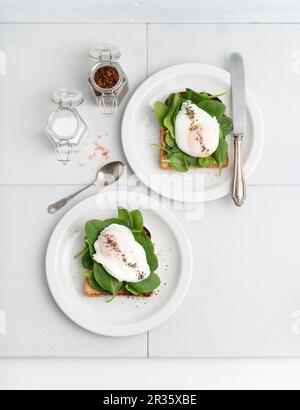 Toast recouvert de jeunes épinards et d'œufs pochés Banque D'Images