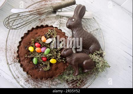 Tarte au chocolat avec thym caramélisé, œufs de sucre et lapins de Pâques au chocolat Banque D'Images