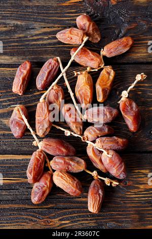 Des dates fraîches sur une table en bois Banque D'Images