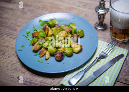 Pommes de terre frites avec saucisses et choux de Bruxelles Banque D'Images