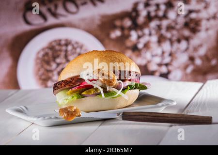 Rouleau de pain de viande sur une assiette avec un couteau de moutarde à la figue au premier plan Banque D'Images