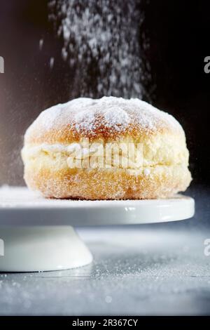 Un beignet saupoudré avec du sucre glace (gros plan) Banque D'Images