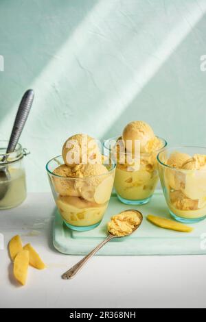 Glace à la mangue avec une cuillère à glace Banque D'Images