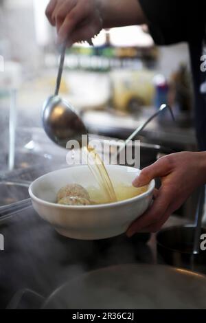 Soupe de boulettes en cours de louage dans un bol (Tyrol du Sud) Banque D'Images