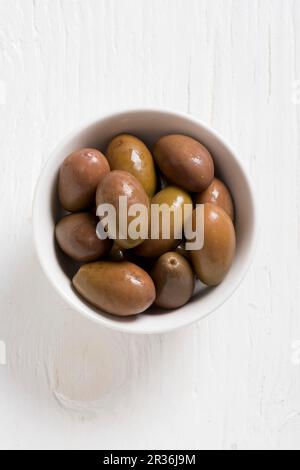 Olives vertes dans un bol blanc Banque D'Images