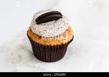 Un cupcake décoré avec de la crème de café et un Oreo Banque D'Images